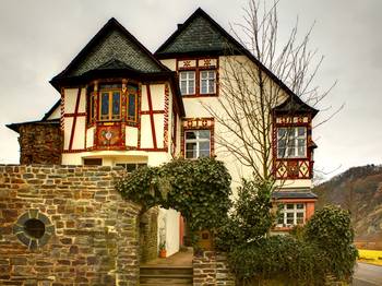 Пример красивой отделки фасада дома пестрого цвета в фахверка стиле