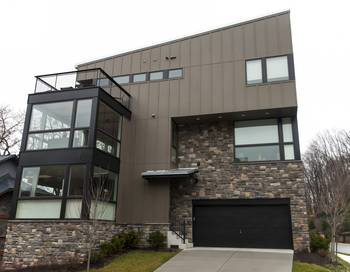 Пример красивой отделки фасада дома серого цвета в современном стиле