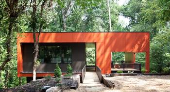Фото дома оранжевого цвета с ограждением