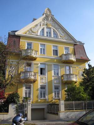 Отделка фасада дома желтого цвета с лепниной