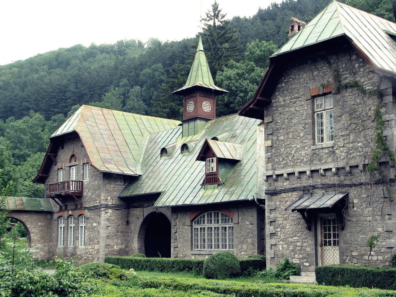 Каменный дом в стиле тюдор с зеленой крышей