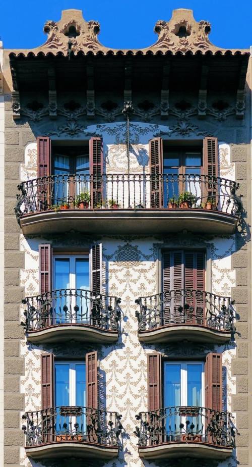 Симметричный фасад с кованными балконами и трафаретом по штукатурке
