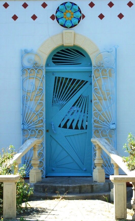Голубые двери с геометрическими узорами и кованными ставнями