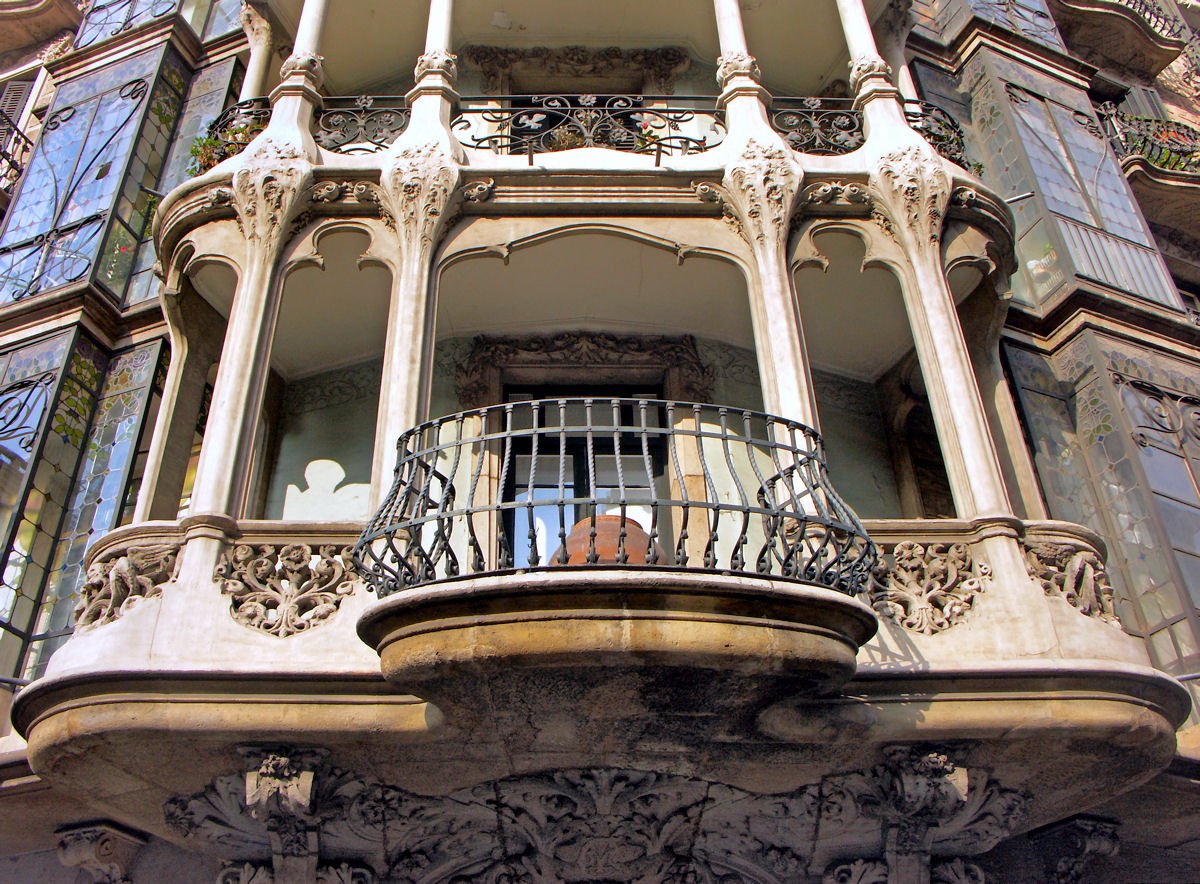 Массивный балкон в стиле модерн с изобилием декора и кованой вставкой