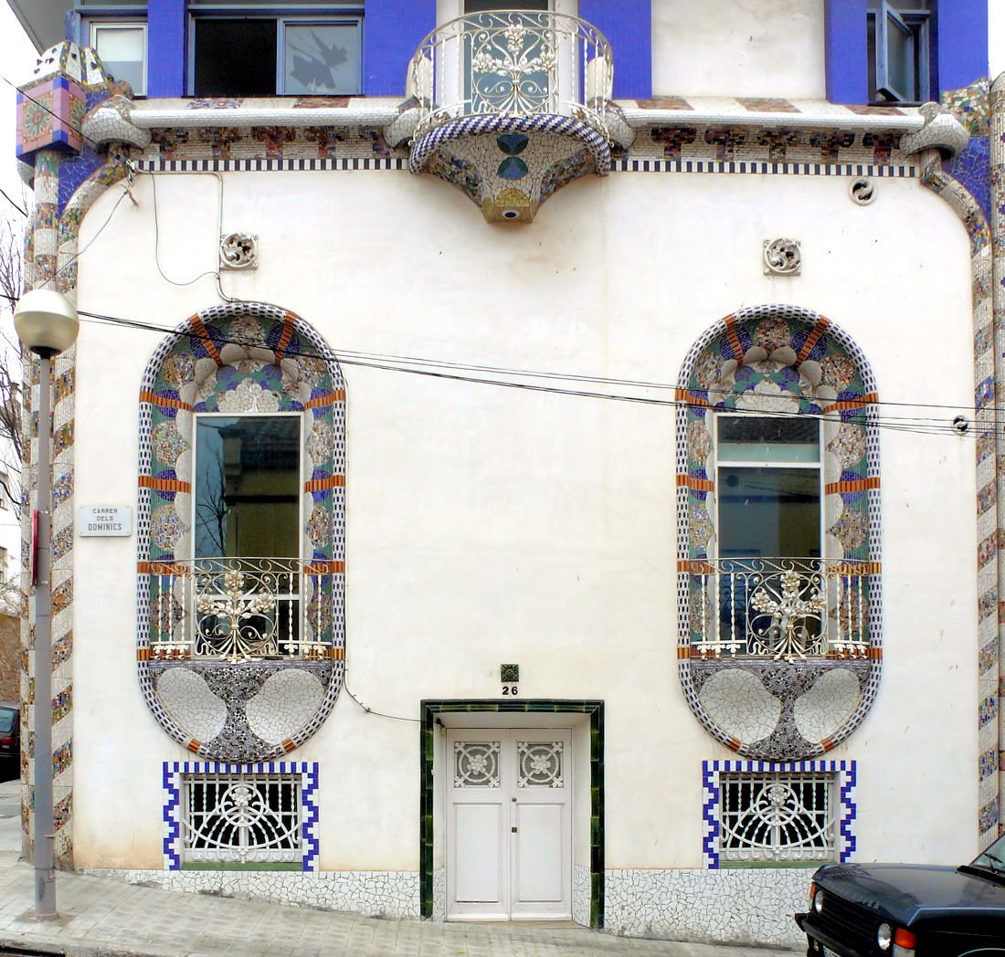 Необычный белый фасад с керамической мозаикой и большими овальными оконными нишами