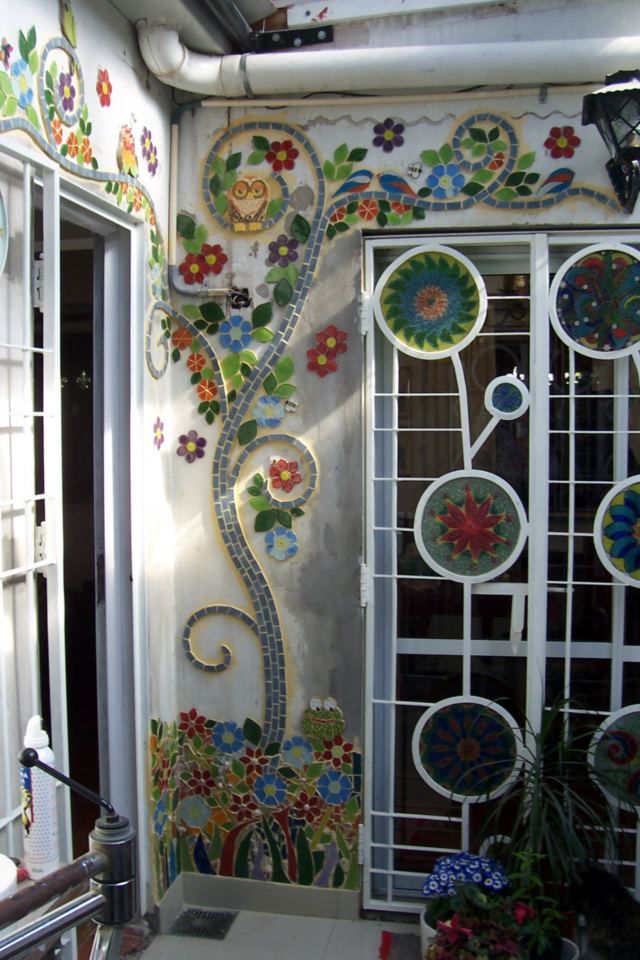 Цветочный узор из мозаики на белой стене
