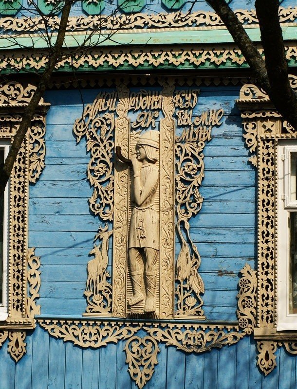 Дизайн фасада деревянного дома синего цвета в деревенском стиле с узорами