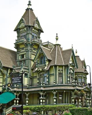 Особняк зеленого цвета со сложной архитектурой и обилием декора