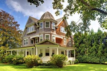 Пример красивой отделки фасада дома пестрого цвета в викторианском стиле