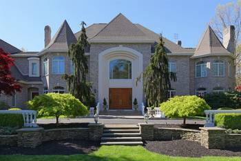 Пример красивой отделки фасада дома серого цвета в готическом стиле