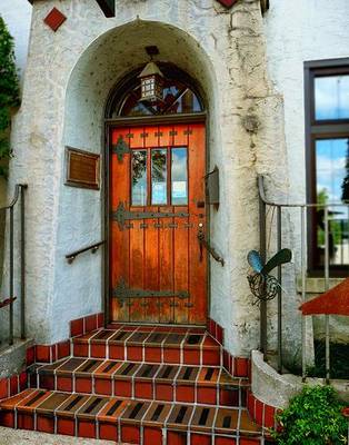 Облицовка фасада дома в готическом стиле с красивой дверью