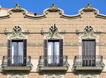 Облицовка коттеджа бежевого цвета с красивым балконом