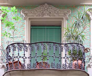 Кованный балкон с зеленым обрамлением в стиле арнуво