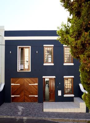 Дизайн дома синего цвета с интересными окнами