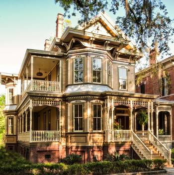 Пример красивой отделки фасада дома бежевого цвета в викторианском стиле