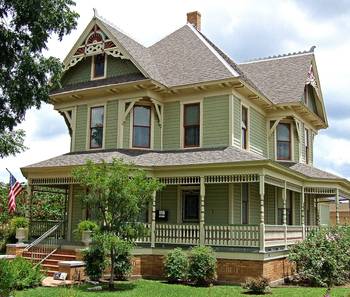 Пример красивой отделки фасада дома зеленого цвета в викторианском стиле