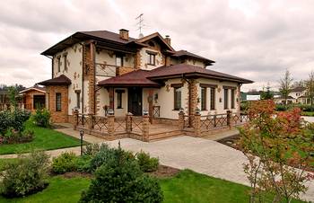 Красивый дом бежевого цвета в эклектичном стиле