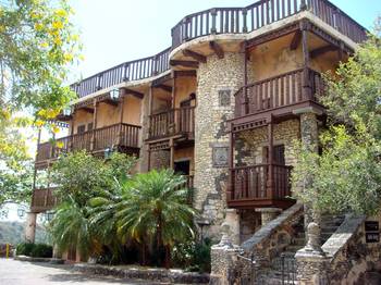 Отделка фасада дома бежевого цвета с красивым балконом