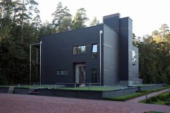 Дизайн дома черного цвета с интересными окнами