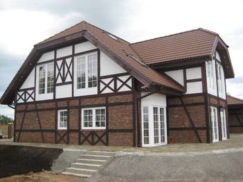 Отделка фасада дома пестрого цвета в фахверка стиле
