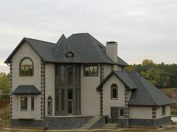 Дом серого цвета с интересными окнами