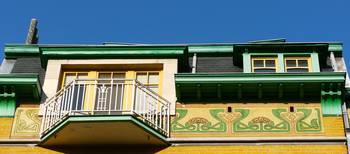 Отделка загородного дома пестрого цвета с красивым балконом
