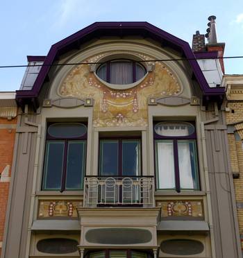 Облицовка коттеджа пестрого цвета с красивым балконом