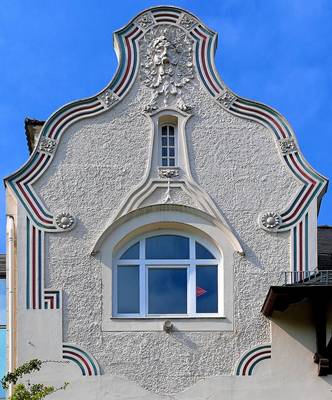 Дизайн фасада дома серого цвета с лепниной