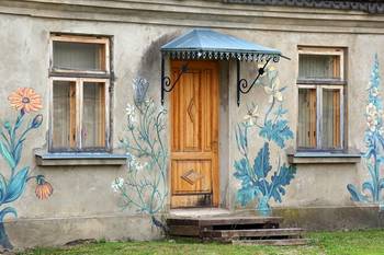 Облицовка коттеджа пестрого цвета с красивой дверью