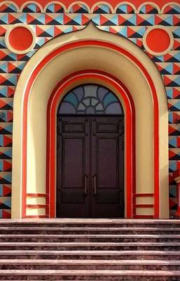 Отделка фасада дома пестрого цвета с красивой дверью