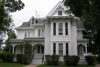 Пример отделки фасада дома белого цвета в викторианском стиле