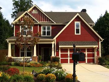 Пример красивой отделки фасада дома красного цвета в тюдора стиле