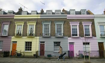 Облицовка фасада дома пестрого цвета с интересными окнами