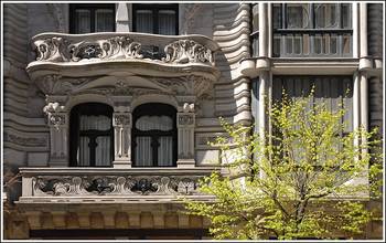 Пример облицовки дома бежевого цвета с красивым балконом