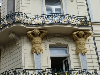 Облицовка фасада дома бежевого цвета с красивым балконом