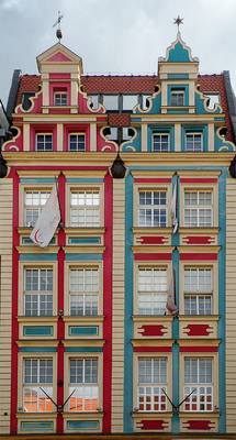 Пример красивой отделки фасада дома пестрого цвета в нормандском стиле