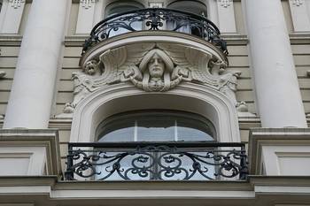 Пример красивой отделки фасада дома серого цвета в ампир стиле