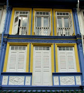 Облицовка фасада дома пестрого цвета со ставнями