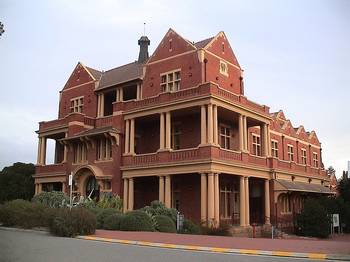 Пример отделки фасада дома красного цвета в викторианском стиле
