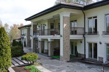 Пример красивой отделки фасада дома пестрого цвета в палладианском стиле