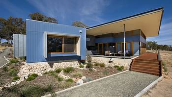 Пример красивого фасада синего цвета с интересными окнами