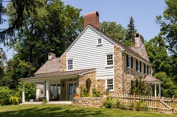 Пример красивой отделки фасада дома пестрого цвета в кантри стиле