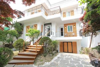 Дизайн фасада дома пестрого цвета с красивым балконом