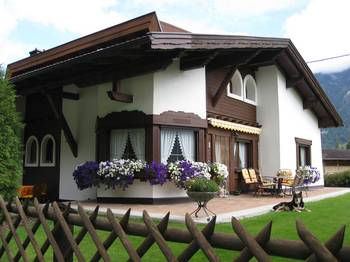 Пример красивой отделки фасада дома пестрого цвета в шале стиле