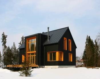 Дом черного цвета с интересными окнами