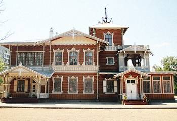 Пример красивой отделки фасада дома коричневого цвета в псевдорусском стиле