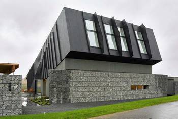 Пример красивой отделки фасада дома черного цвета в современном стиле
