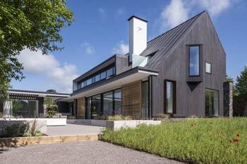 Пример красивой отделки фасада дома серого цвета в барнхаус стиле