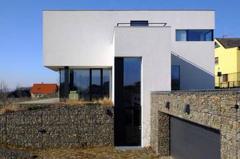 Пример красивой отделки фасада дома белого цвета в современном стиле