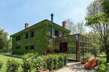 Пример красивой отделки фасада дома зеленого цвета в авторского стиле